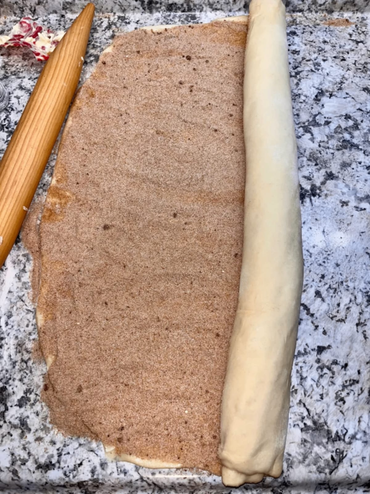 Rolling up the cinnamon roll dough with filling